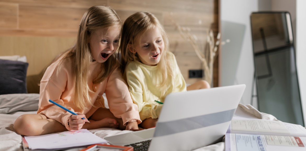 two young girls using a computer